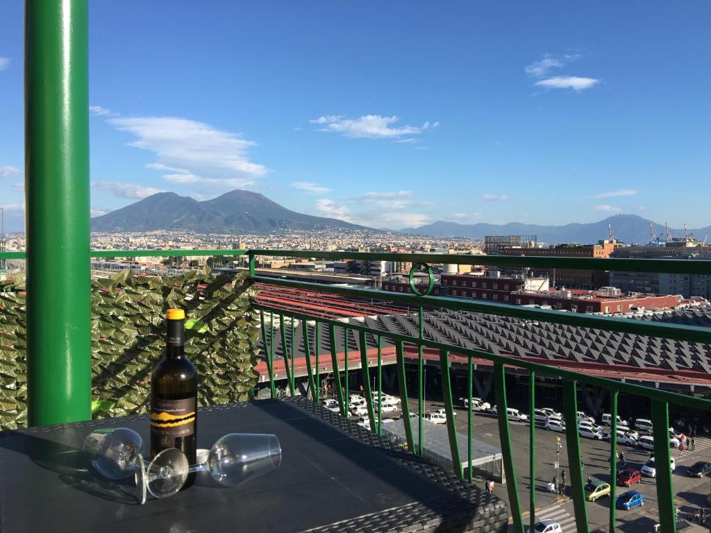 Una botella de vino sentada en una mesa en un balcón en Top Floor Rentrooms Napoli en Nápoles