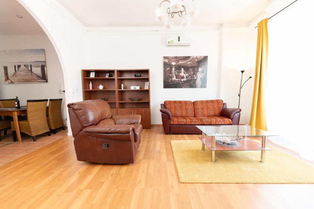 een woonkamer met 2 banken en een glazen tafel bij Danube Dwelling Asboth 19-1 in Boedapest