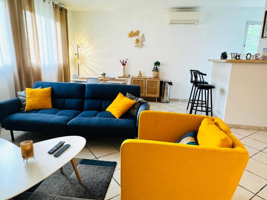 - un salon avec un canapé bleu et des fauteuils jaunes dans l'établissement Las Sorbes - T3 - Spacieux lumineux, climatisé, à Montpellier