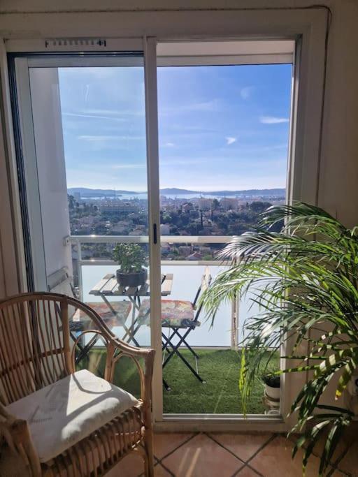 Cette chambre dispose d'une porte coulissante en verre avec une table sur le balcon. dans l'établissement Superbe appartement T3 lumineux, à Toulon