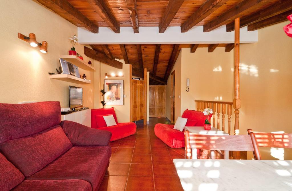 a living room with red couches and a table at Atico Preciados in Madrid