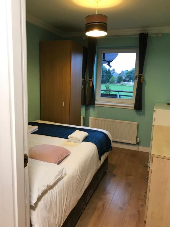 una camera da letto con un grande letto e una finestra di holiday Apartment with two bathrooms, lift access a Edimburgo