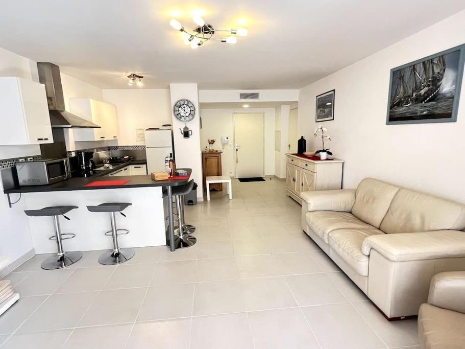 Il comprend un grand salon avec un canapé et une cuisine. dans l'établissement Figuerolles Moderne T3-300m Mer-Plage-Port-Parking-3 Étoiles, à La Ciotat