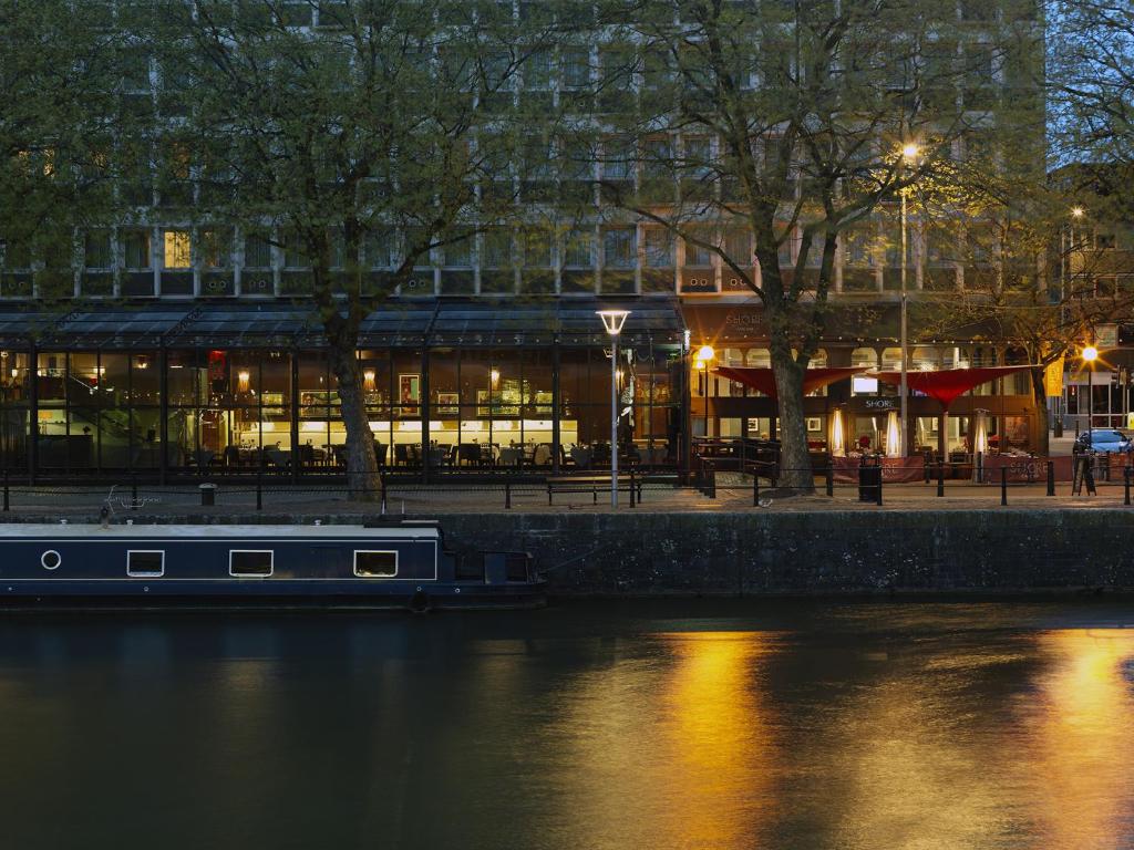 un barco en el agua frente a un edificio en The Bristol Hotel en Bristol