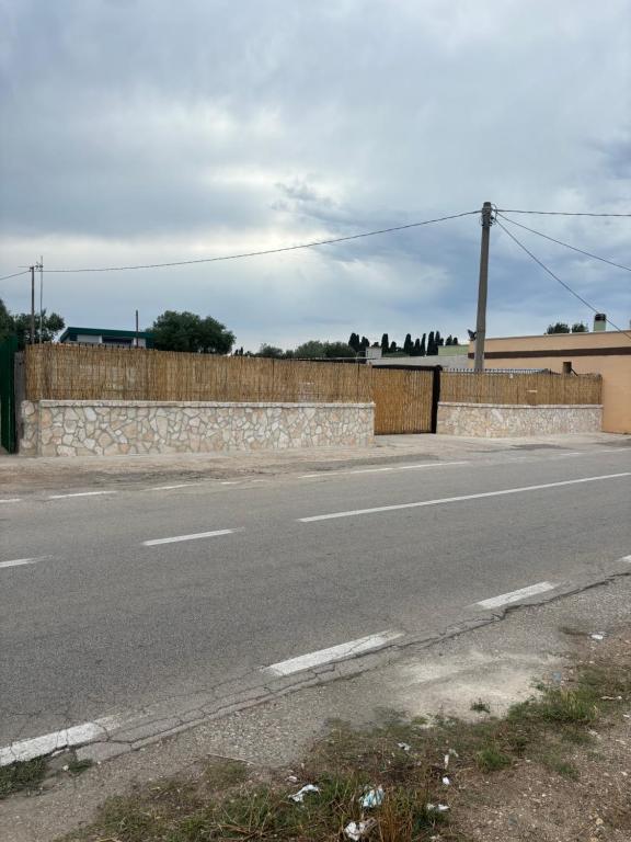 uma estrada vazia ao lado de uma parede de pedra em DON BOSCO 2 em Bari Palese