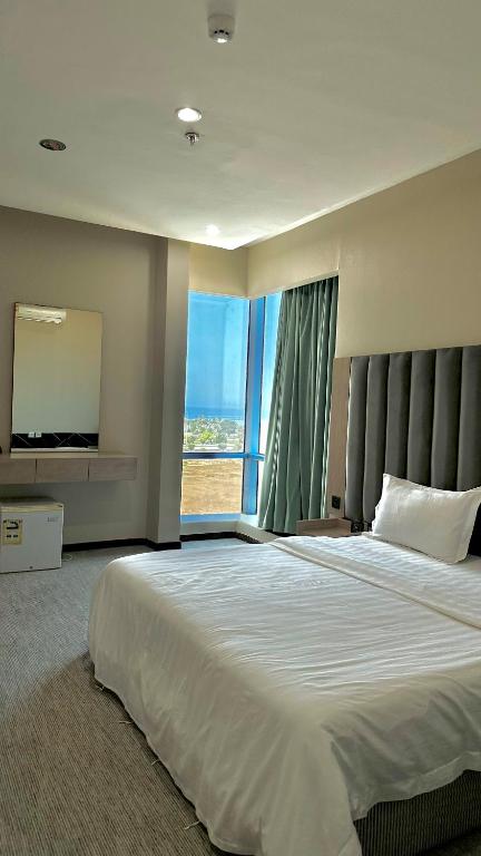 a large bedroom with a large bed and a large window at شقق الريم الجديد للشقق المخدومة Al Reem Al Jadid residence in Yanbu