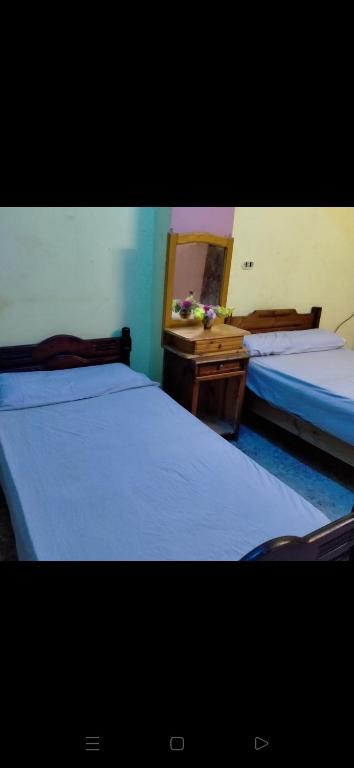 1 dormitorio con 2 camas, tocador y espejo en Santa Maria en Marsa Matruh