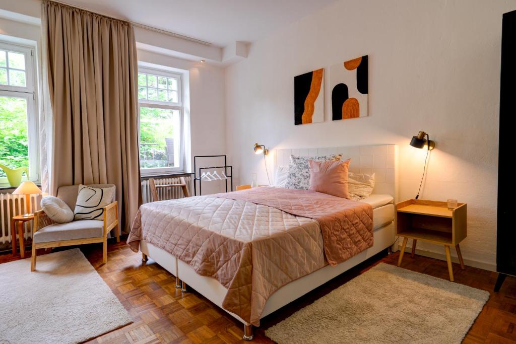 um quarto com uma cama, uma cadeira e janelas em Apartment mit 2 Schlafzimmern am Bergpark Wilhelmshöhe em Kassel