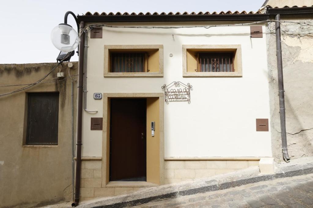 - un bâtiment blanc avec une porte et 2 fenêtres dans l'établissement A casa do Caliaru, à Leonforte