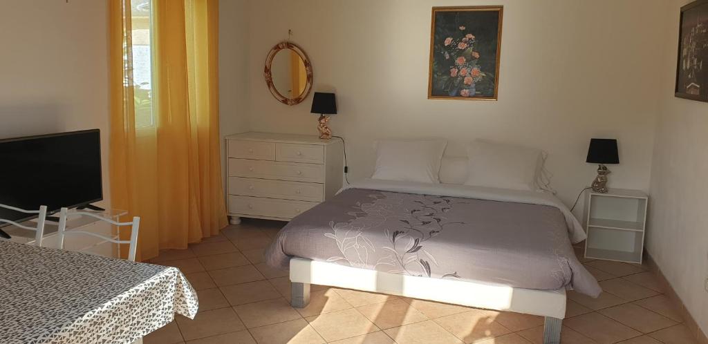 - une chambre avec un lit, une commode et une télévision dans l'établissement House Angeli, à Prunelli-di-Fiumorbo