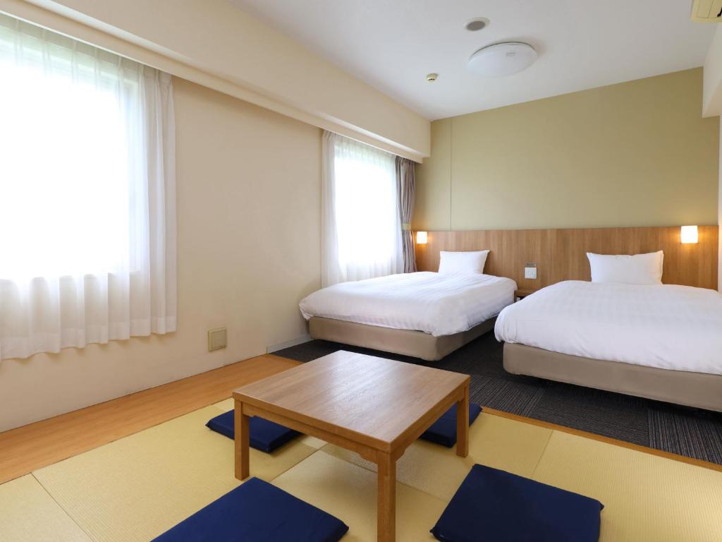 Postel nebo postele na pokoji v ubytování Dormy Inn Express Mikawaanjo