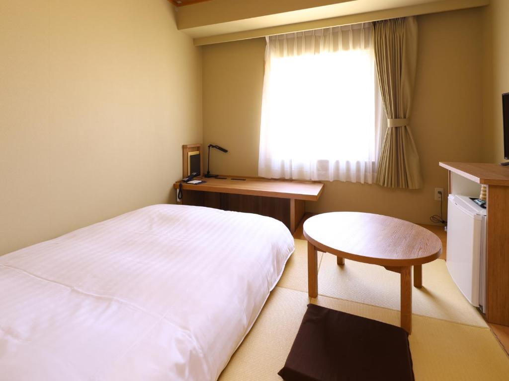 Postel nebo postele na pokoji v ubytování Dormy Inn Express Mikawaanjo
