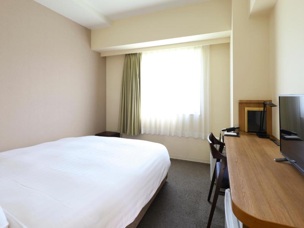 Postel nebo postele na pokoji v ubytování Dormy Inn Express Mikawaanjo