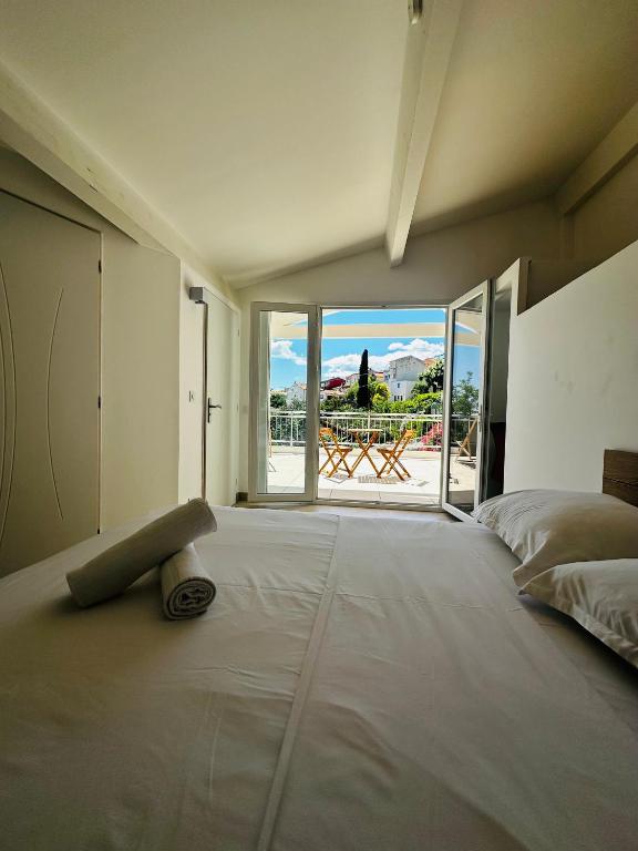 une chambre avec un grand lit avec une grande fenêtre dans l'établissement Les luxueuses terrasses du Roucas, à Marseille