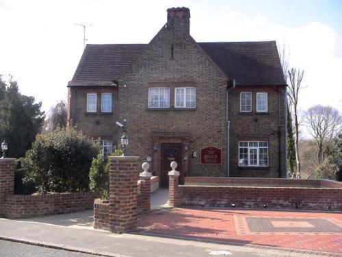 una gran casa de ladrillo con una pared de ladrillo en The Bridge House en Hounslow