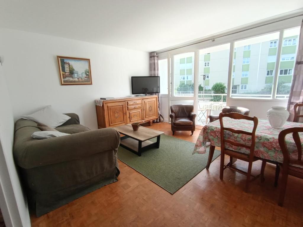a living room with a couch and a tv at Chambre double confort in Paris