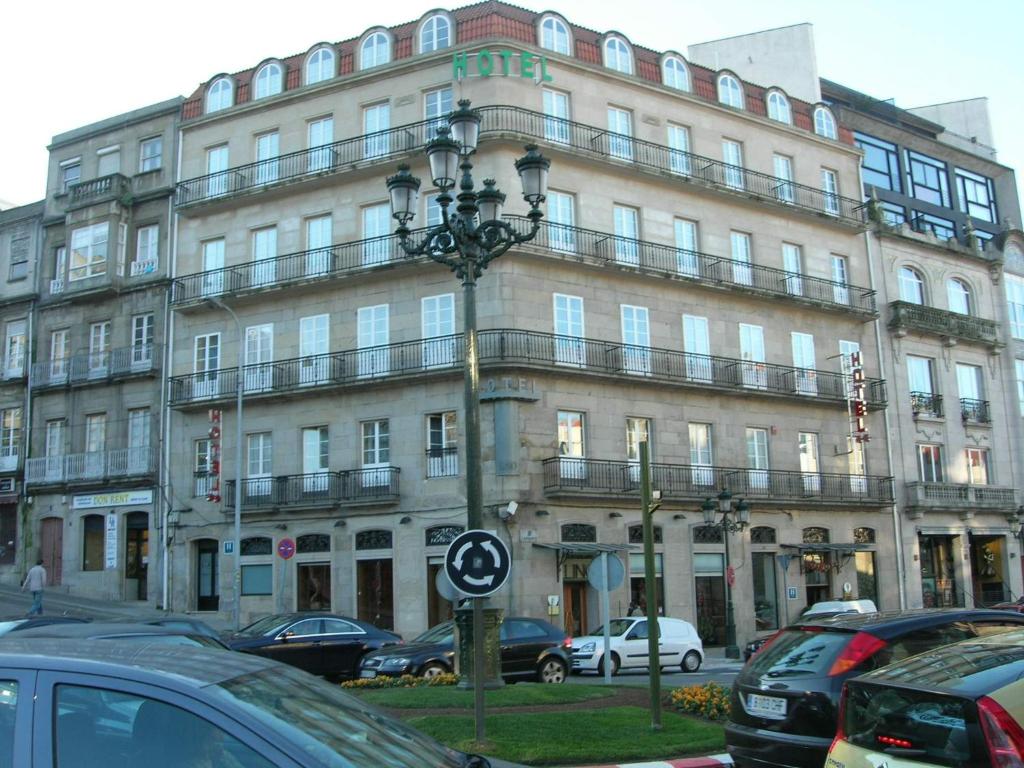 un gran edificio con coches estacionados frente a él en Hotel Lino, en Vigo