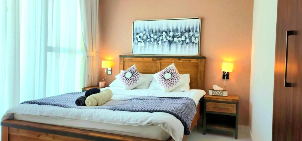 a bedroom with a bed with a person laying on it at Gharfar Verdant Retreat 3Bedroom Villa in Dubai