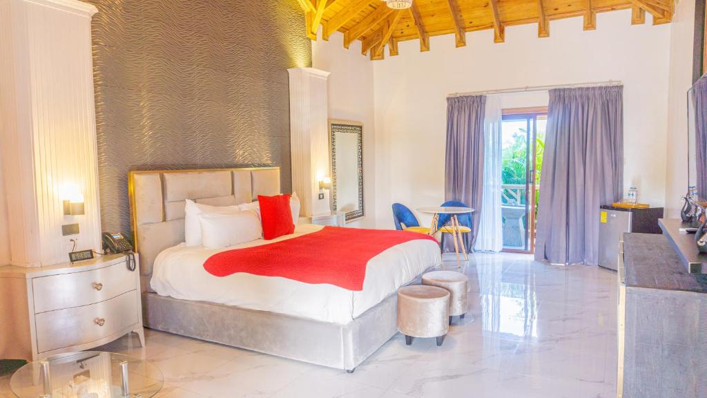 una camera con un letto con una coperta rossa di Brunei Hotel Boutique a Boca Chica