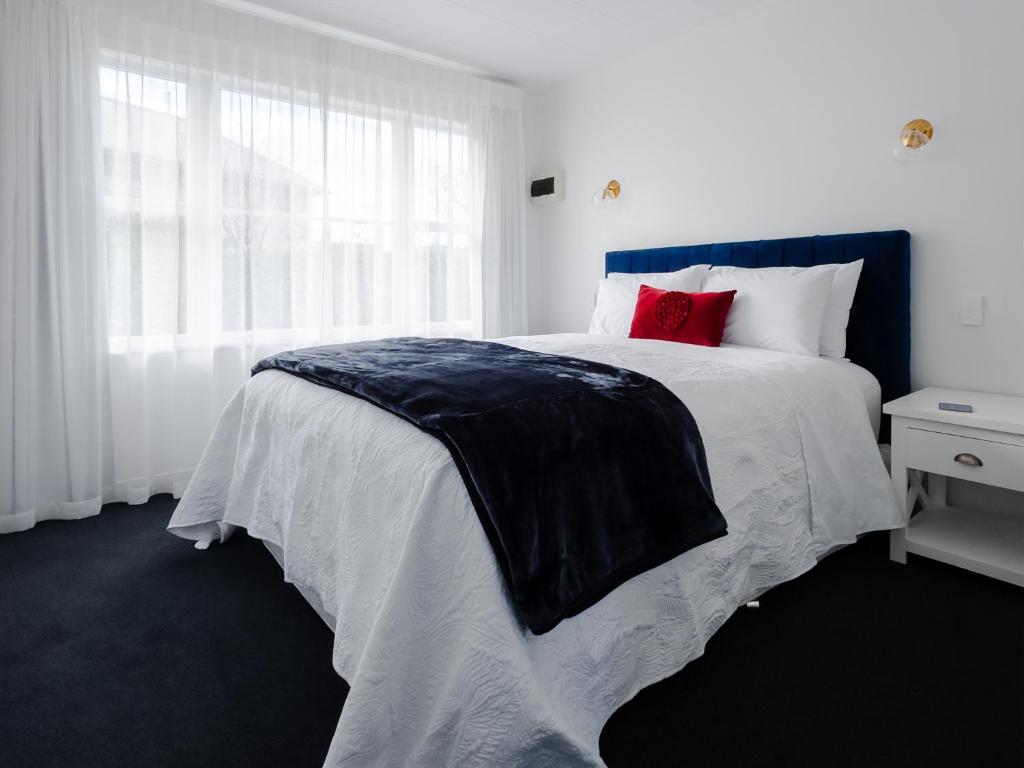 - une chambre avec un grand lit et des oreillers rouges dans l'établissement Kings Cottage, à Cambridge
