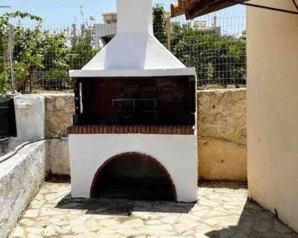 - un poêle blanc avec une cheminée dans la cour dans l'établissement Roupes Stone House in Roupes, à Roúpai