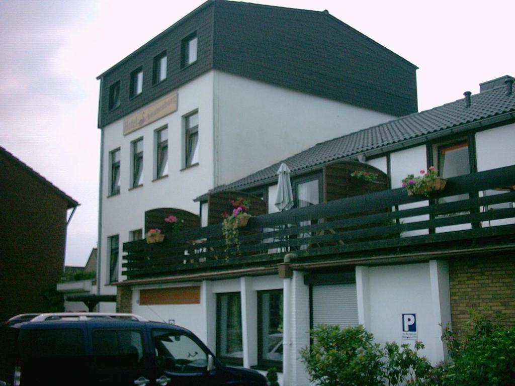 un edificio con un coche aparcado delante de él en Hotel Schwanenburg, en Kleve