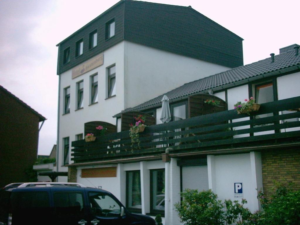 un bâtiment avec une voiture garée devant lui dans l'établissement Hotel Schwanenburg, à Clèves