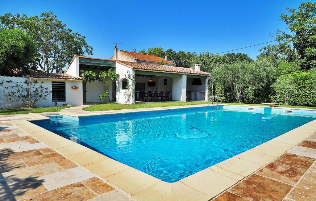a swimming pool in front of a house at Villa Les Sapins in Moulès