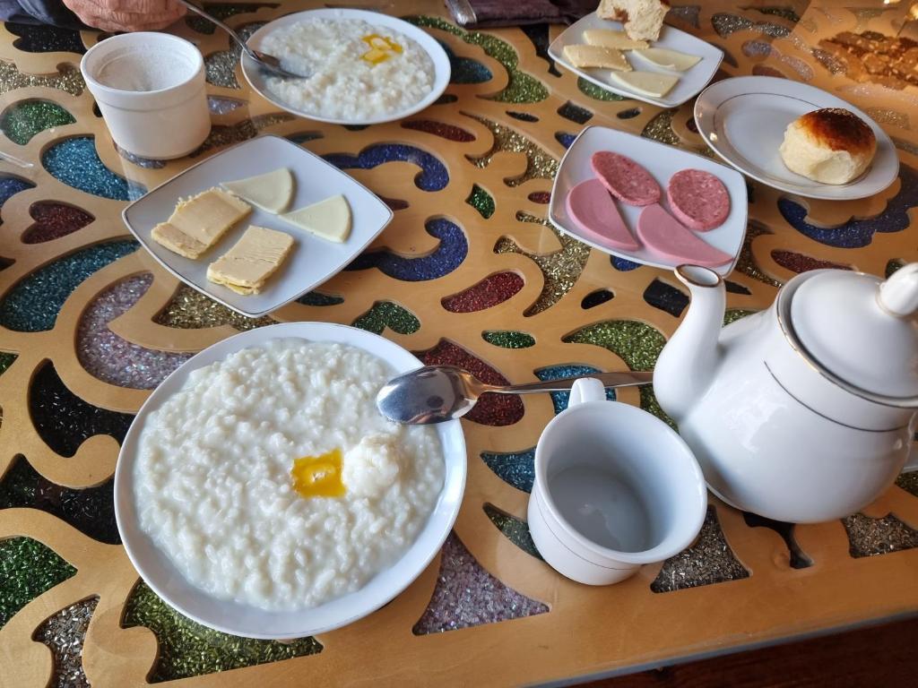 een tafel met een kom rijst en een bord eten bij Квартира in Doesjanbe