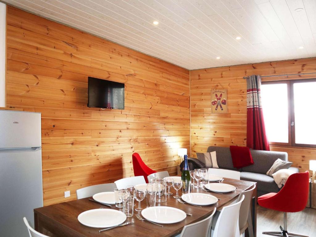 une salle à manger avec une table et des chaises rouges dans l'établissement Appartement spacieux pour 10 personnes en station, balcons, en face des pistes - FR-1-322-610, aux Orres