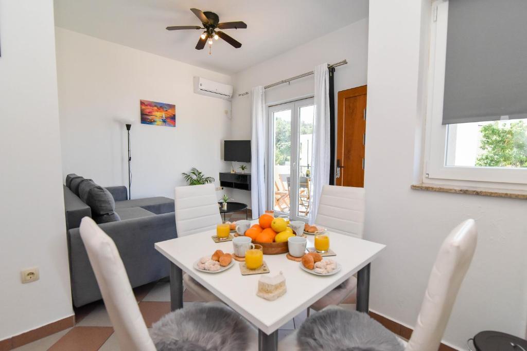 a living room with a white table with fruit on it at Ibeach By Rok Apartment in Novigrad Dalmatia