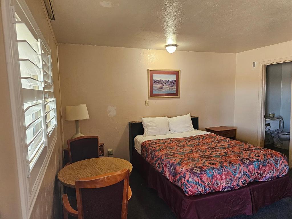 Habitación de hotel con cama y mesa en Sands Motel en Grants