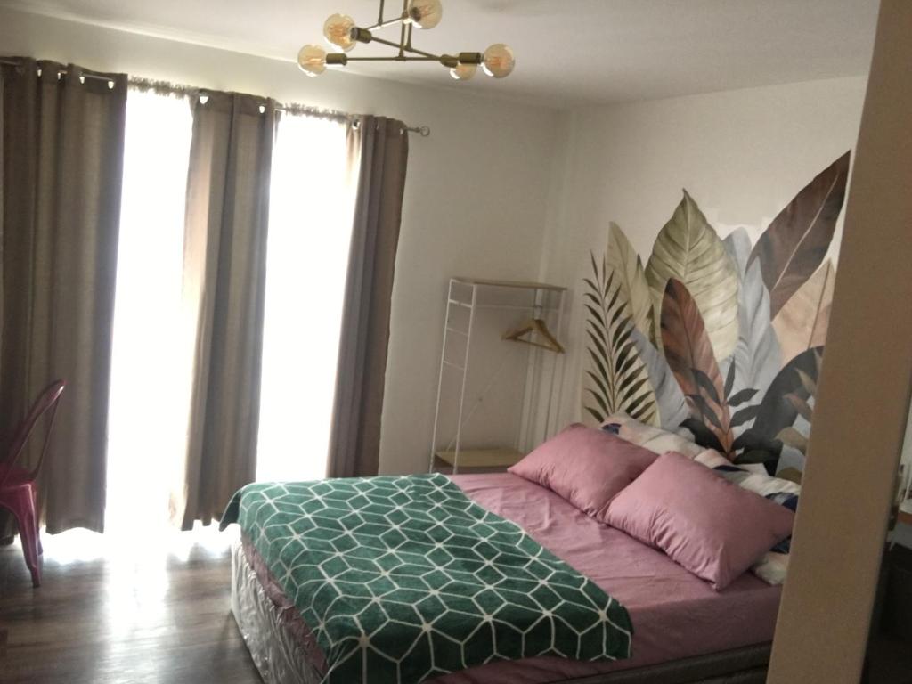 una camera da letto con letto e cuscini rosa di La Reina Suite Tuscania Towers a Cagayan de Oro