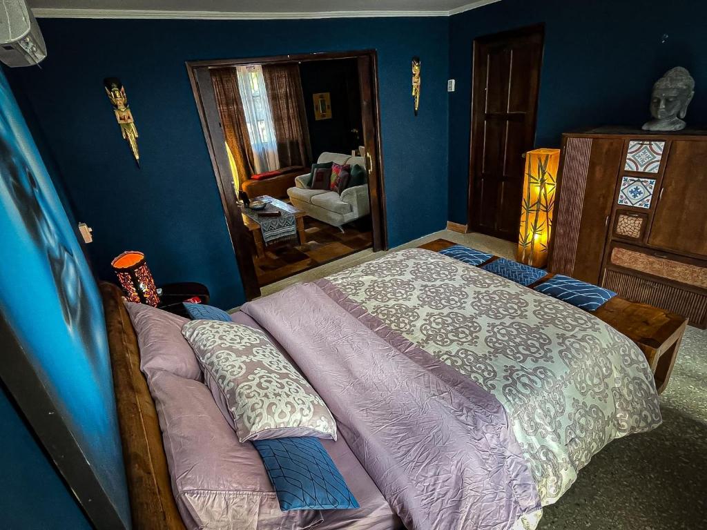 a bedroom with a bed and a blue wall at ORHO HOTEL BOUTIQUE PANAMA Tocumen Airport free shuttle highway round trip 15 minuts in Tocumen