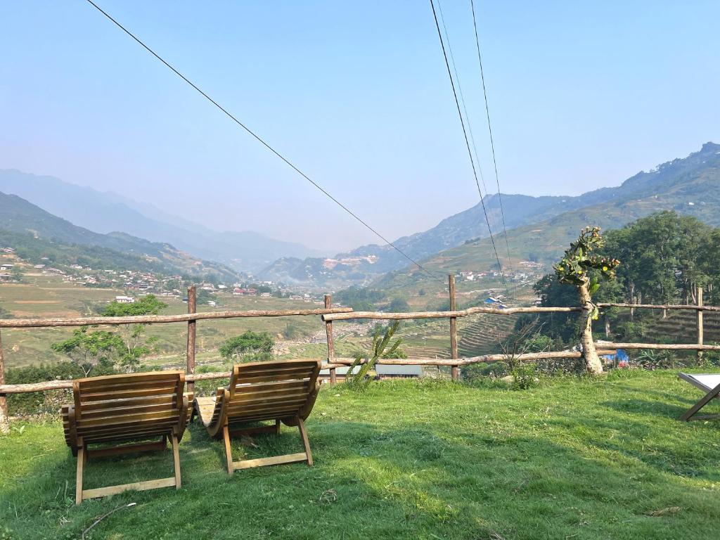 薩帕的住宿－Pavi garden，两把长椅坐在山顶上,享有美景