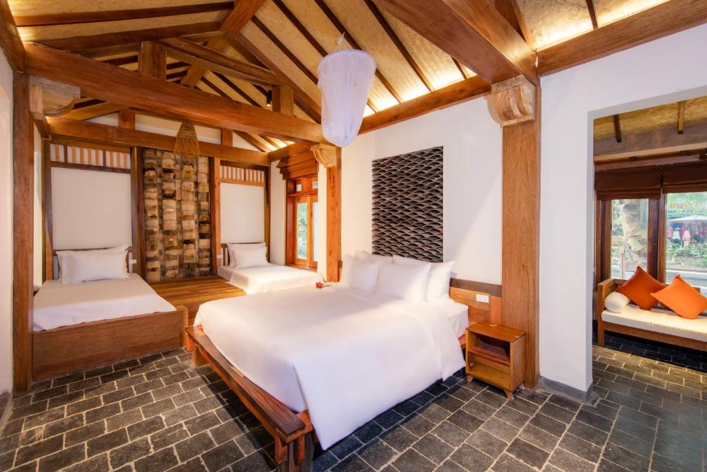 una camera con due letti in una stanza con soffitti in legno di Mua Caves Ecolodge (Hang Mua) a Ninh Binh