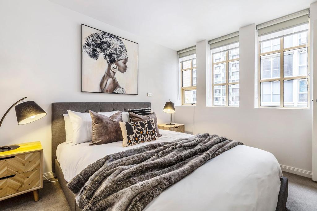 Un dormitorio con una cama con una manta encima. en VAQUAY Tribeca in Melbourne CBD, en Melbourne