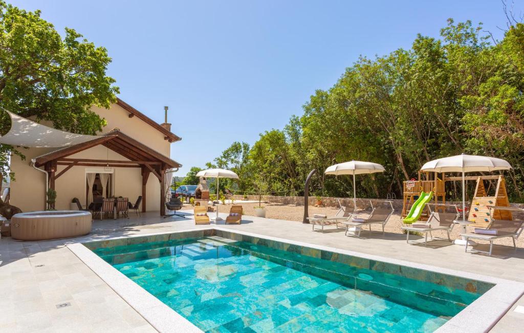 a swimming pool with a slide and a playground at Awesome Home In Bribir With Jacuzzi in Bribir