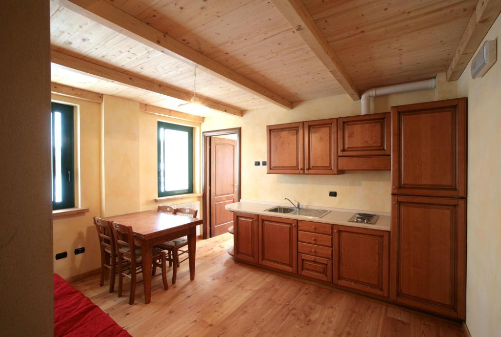 a kitchen with wooden cabinets and a wooden table at Normena Mountain Residence in Tizzano Val Parma