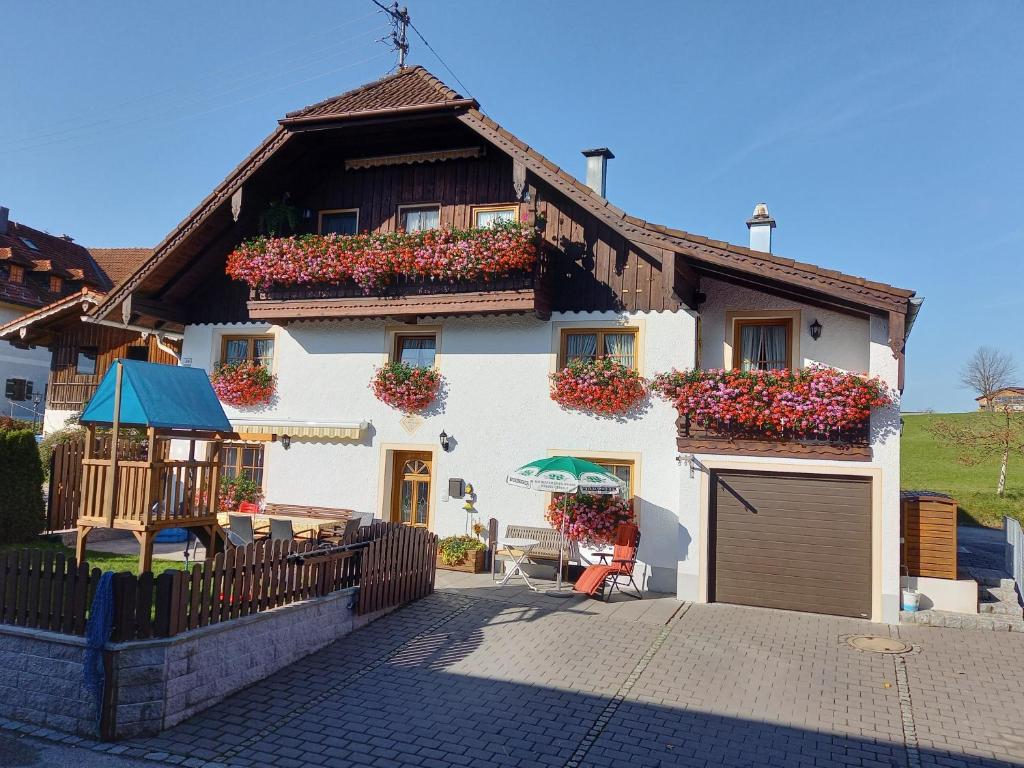 une maison avec des boîtes de fleurs sur son côté dans l'établissement Haus Zaineck, à Anger