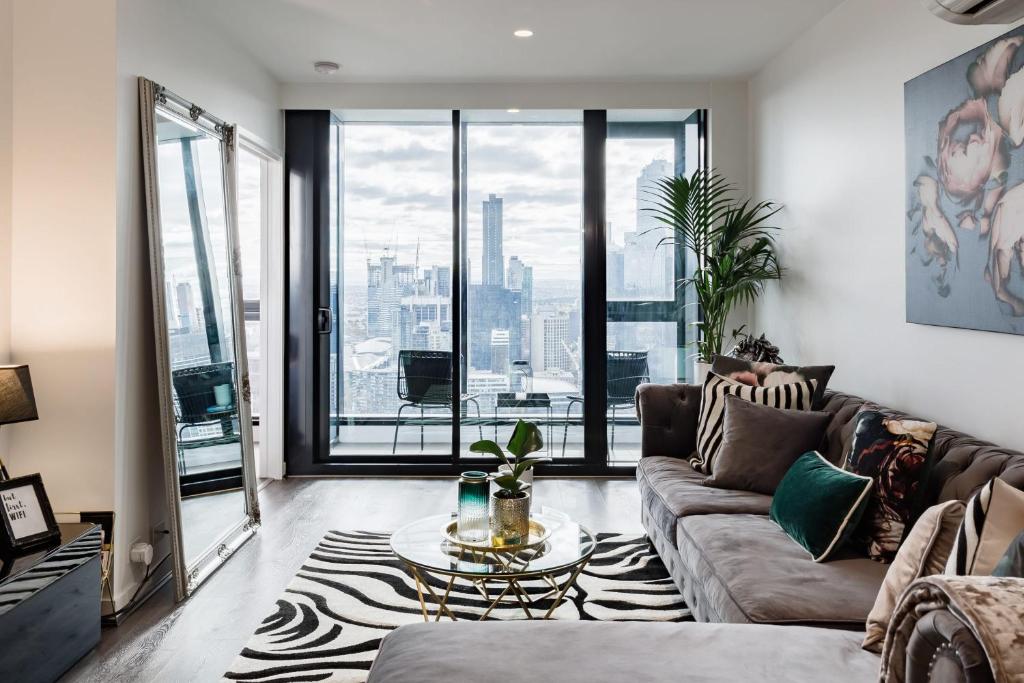 una sala de estar con un sofá y una mesa en VAQUAY Luxor In Southbank, en Melbourne
