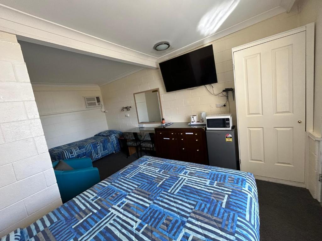 ein Hotelzimmer mit einem Bett, einer Küche und einem Zimmer in der Unterkunft Warren Motor Inn in Warren
