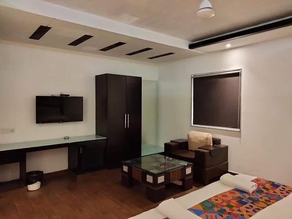 a room with a tv and a bed and a table at Airport Hotel Peebles in New Delhi