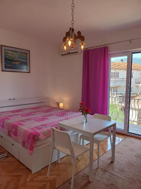 a bedroom with a bed and a table with chairs at Apartments Nela in Jelsa