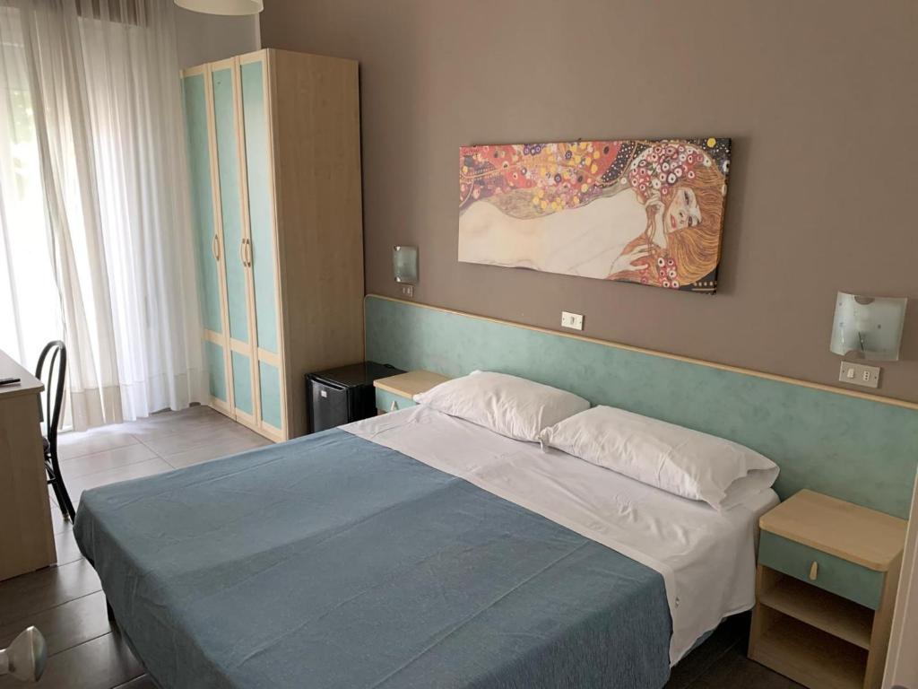 um quarto com uma cama e um quadro na parede em Hotel Abamar em Rimini