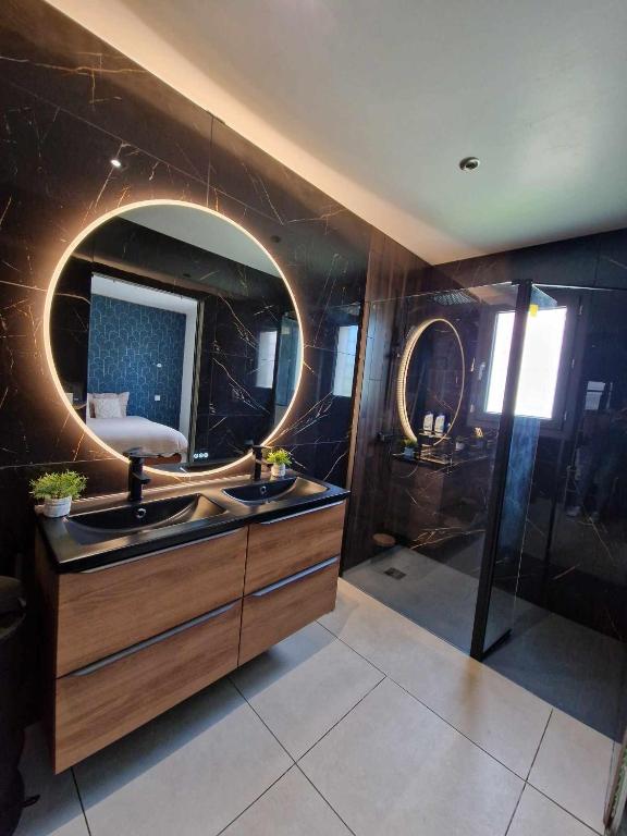 une salle de bain avec un lavabo et un miroir dans l'établissement Paisible villa plain pied 110m2, à Saint-Nazaire
