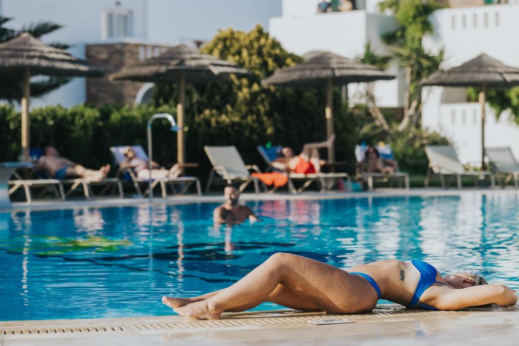 kobieta leżąca na krawędzi basenu w obiekcie Aegean Palace w mieście Plaka