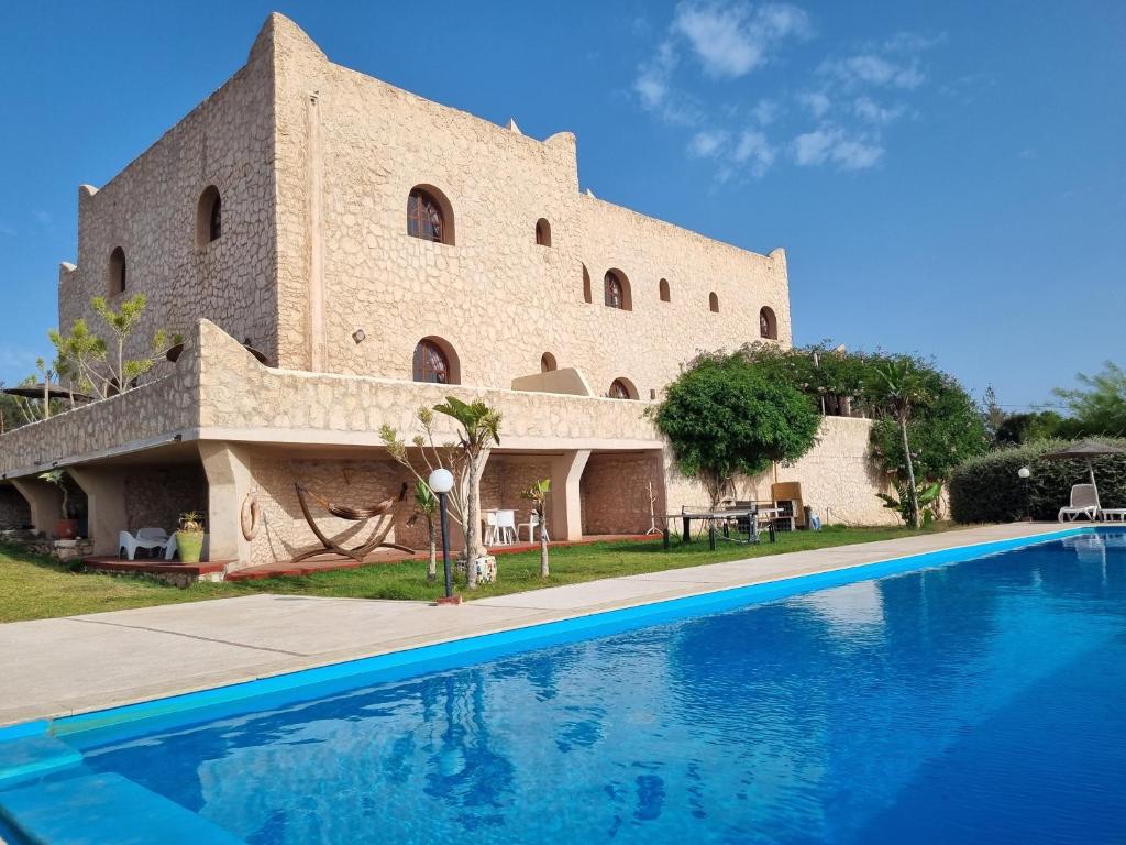 un gran edificio con una piscina frente a él en Dar Essaada, en Essaouira