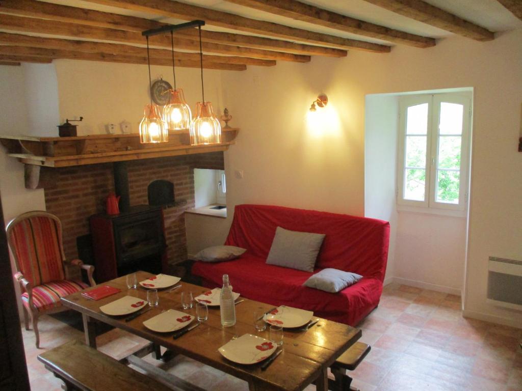 un salon avec un canapé rouge et une table dans l'établissement Bouerzy, à Laruns