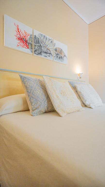 a bedroom with a bed with two pillows on it at Hotel Lu Pitrali in San Teodoro